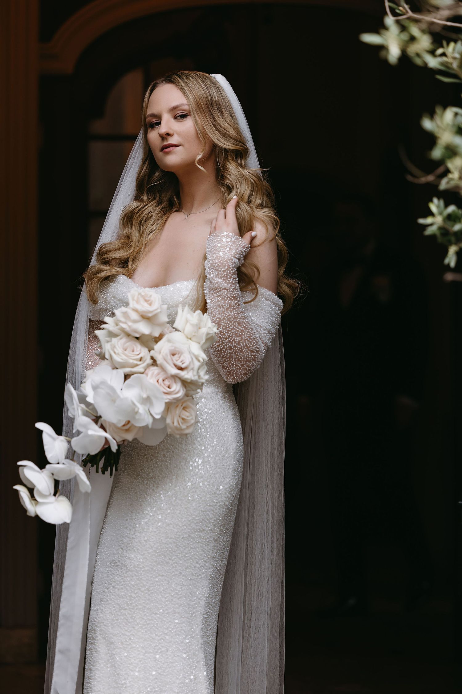 Sparkling white wedding dress with delicate beading detail and a beautiful white floral bouquet.