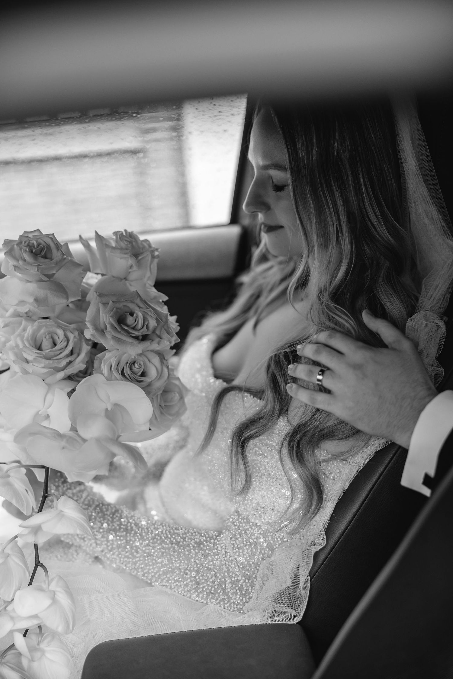 Close-up detail of a beaded wedding dress with white roses.