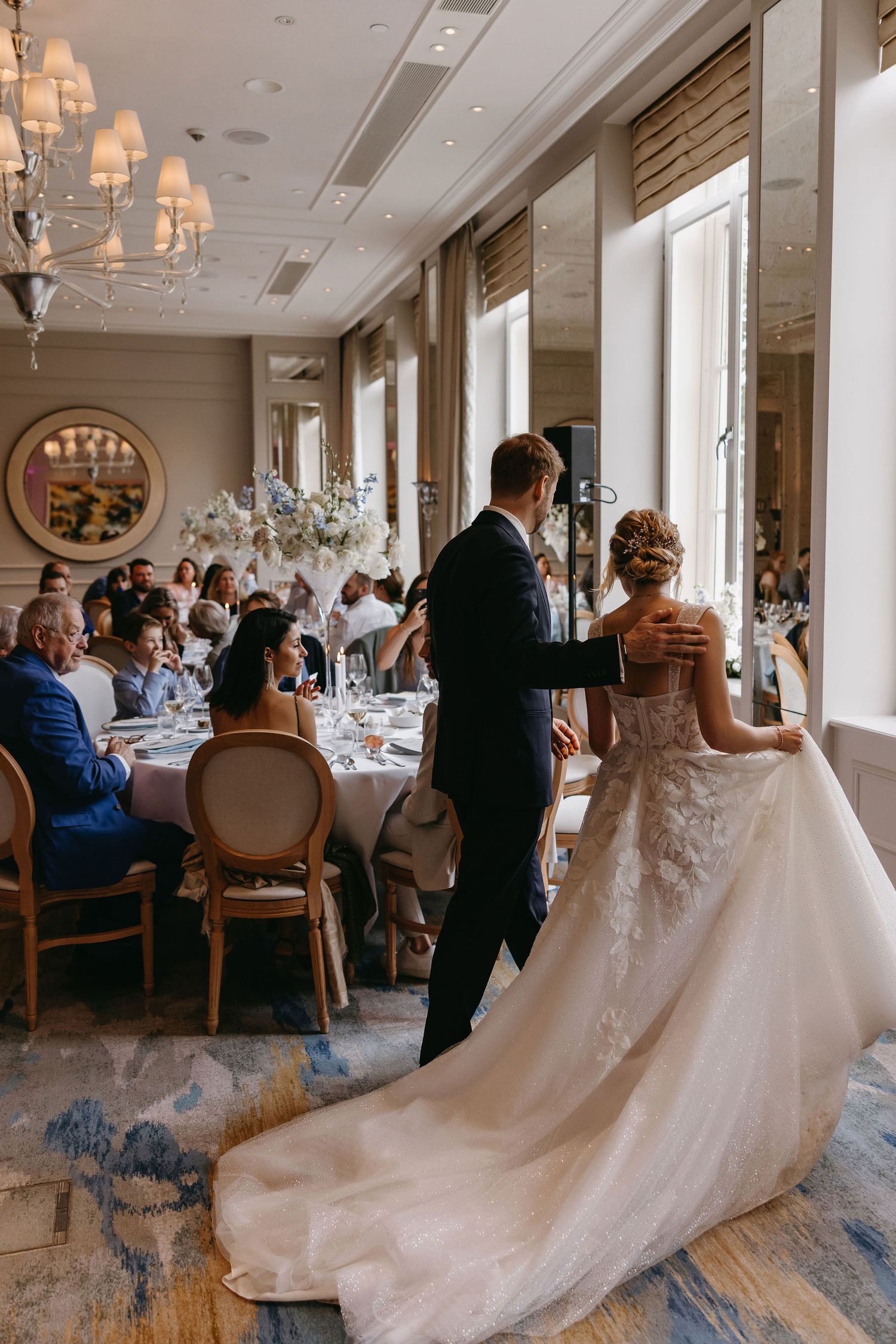 Elegant wedding reception scene with flowing bridal gown in foreground.