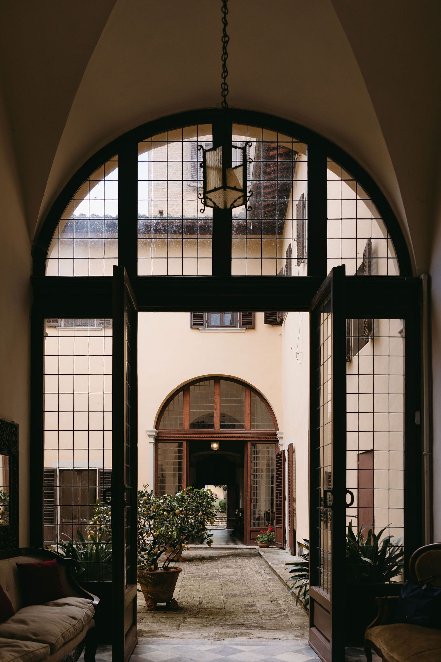 Interior courtyard view through arched windows in an Italian villa.