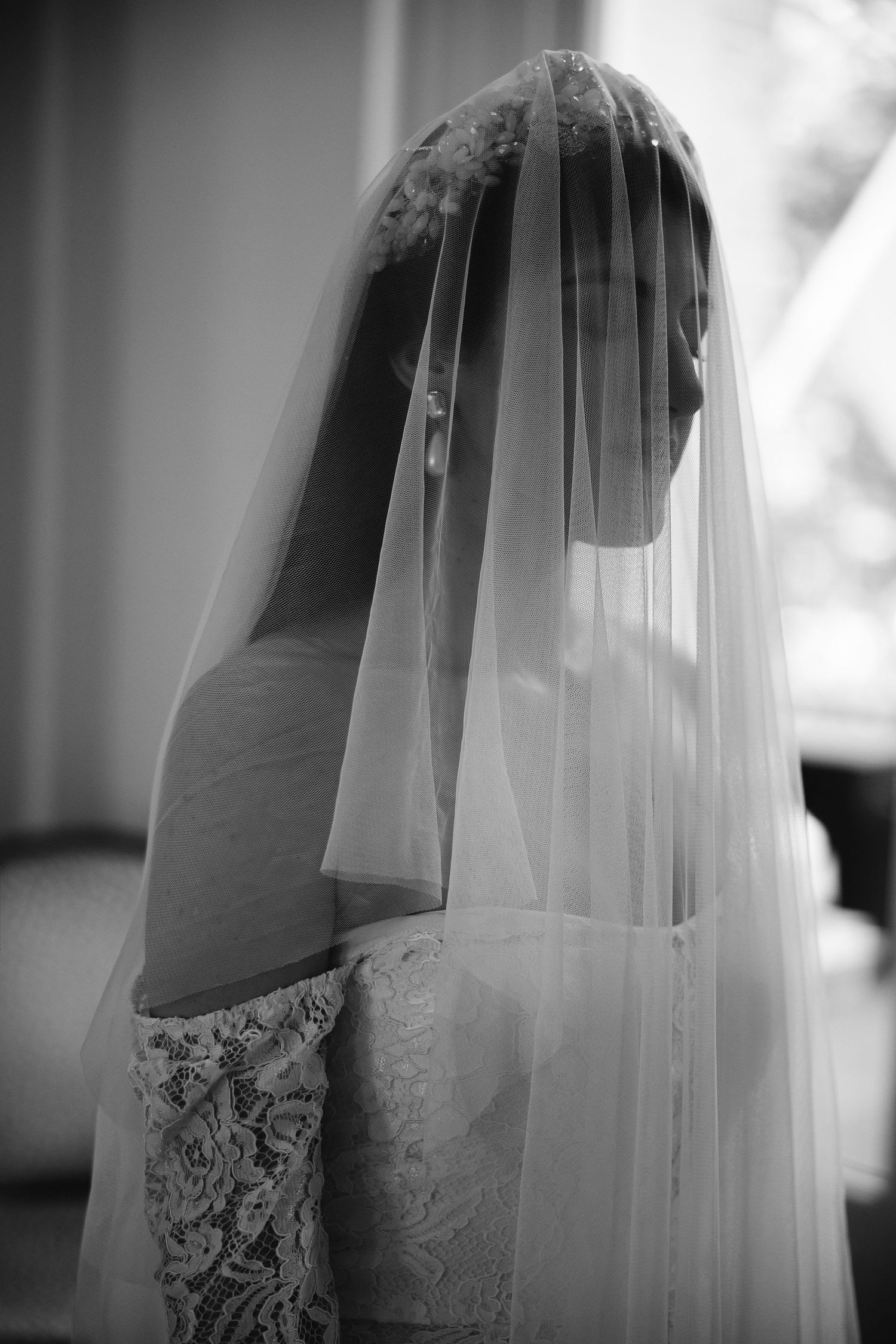 Close-up sequence of a lace wedding dress and veil in black and white photography.
