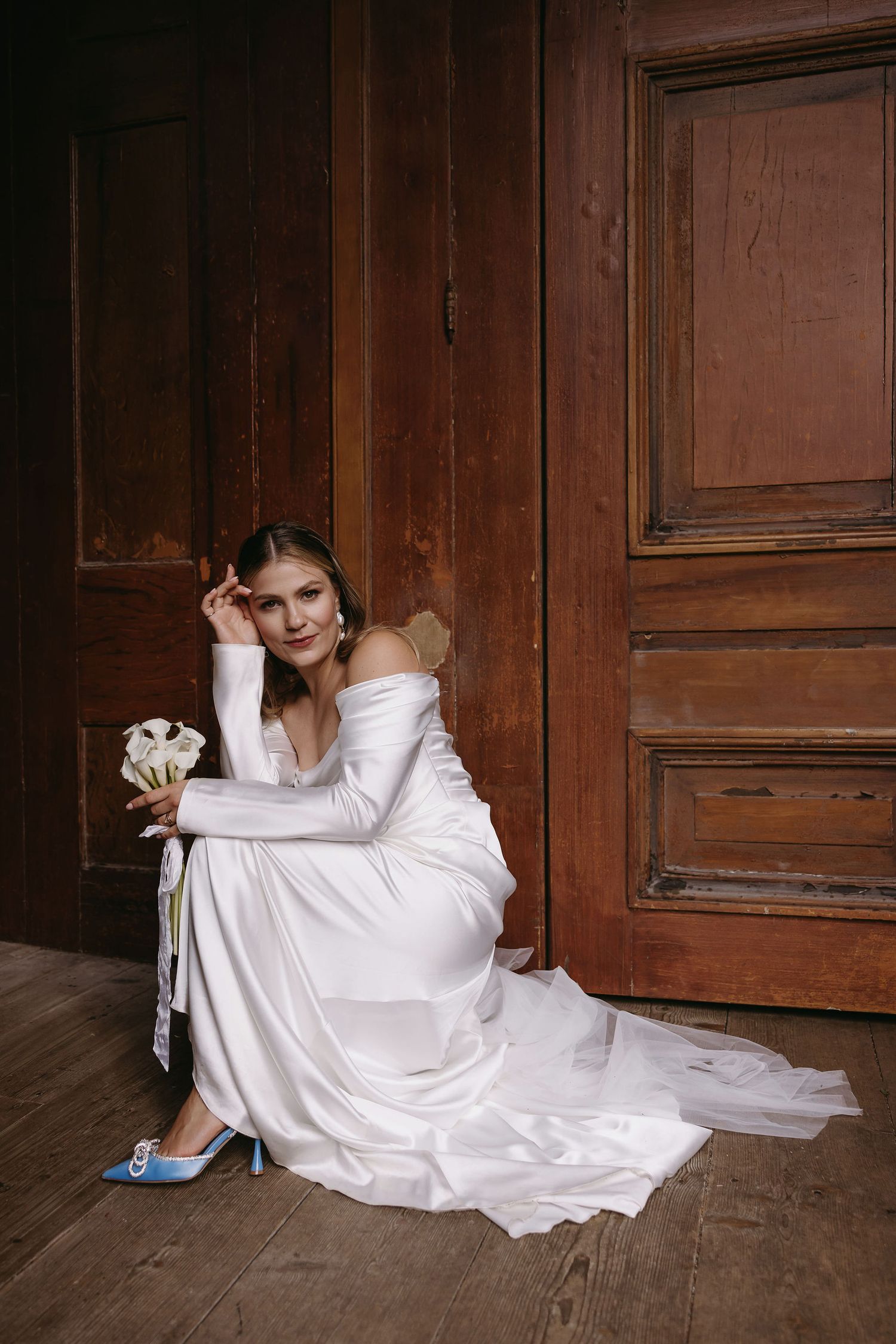 Dramatic black and white sequence of someone in a white wedding dress lying on wooden floor.