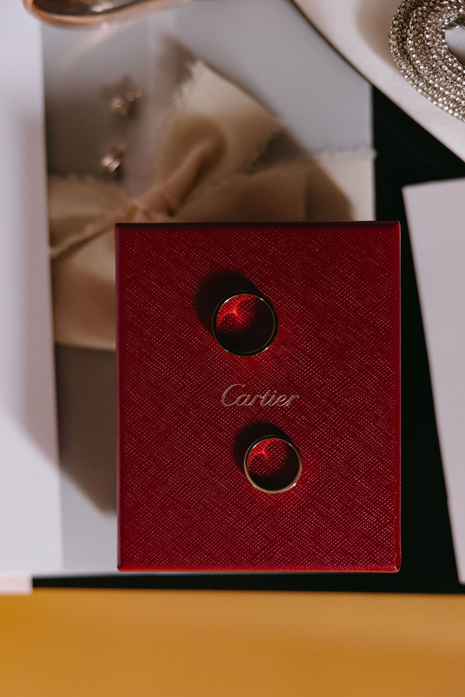 Close-up of red Cartier jewelry box with two circular compartments.