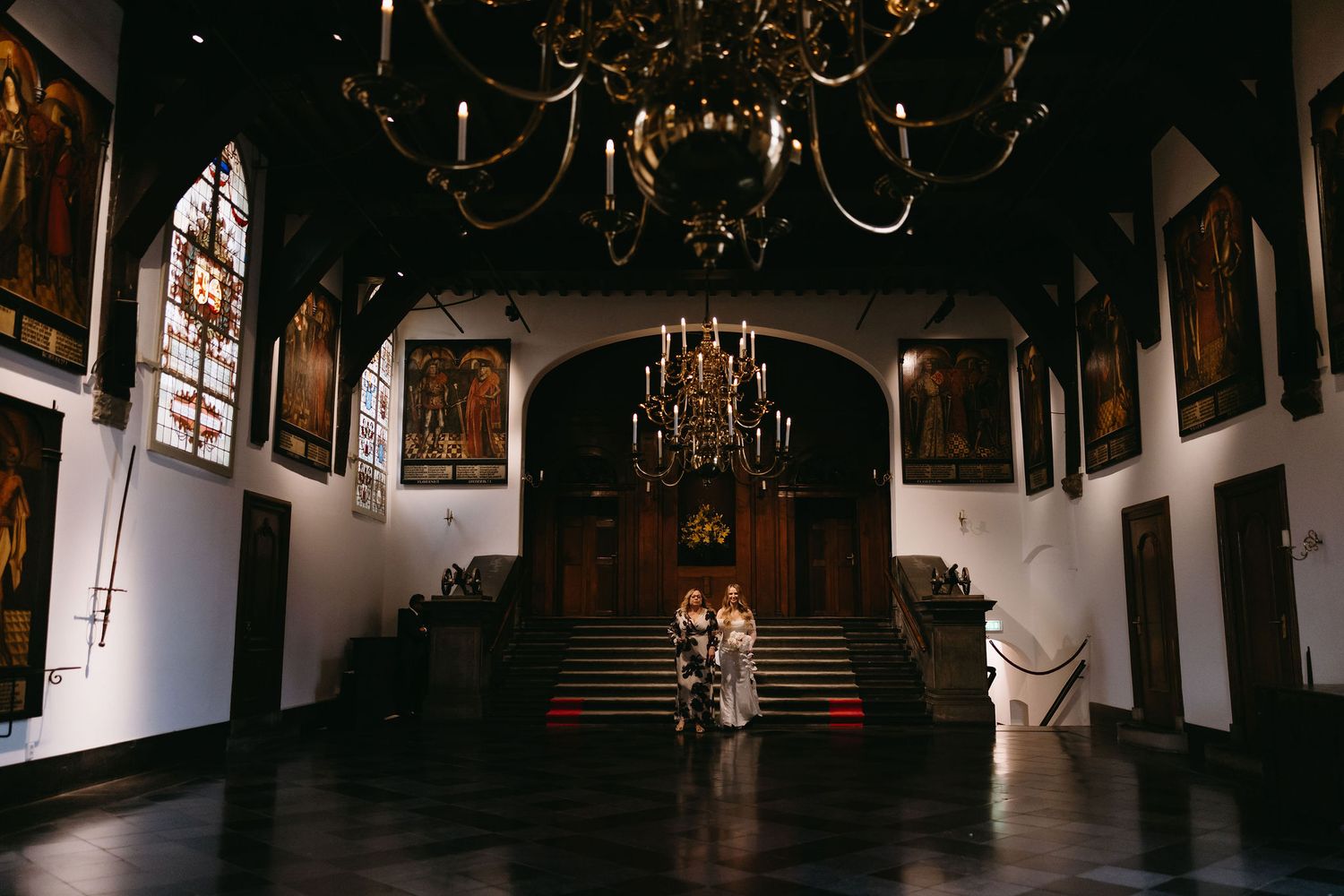 Grand interior of an elegant venue with ornate chandeliers and architectural details.