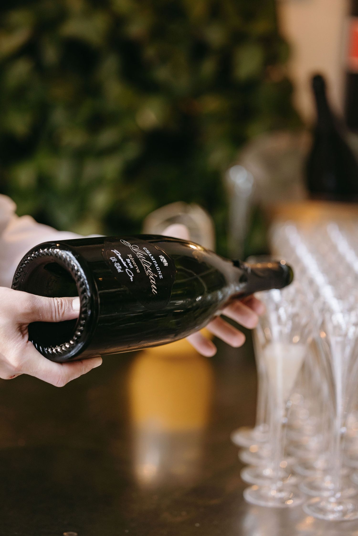 Hand holding vintage champagne bottle at elegant wedding reception.