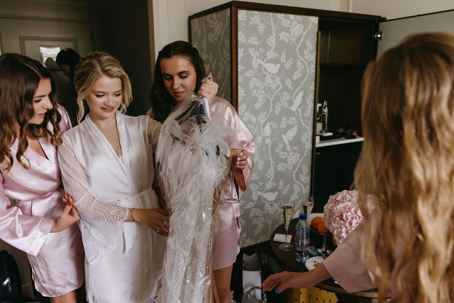 Getting ready scene with people in pink robes preparing for wedding day.