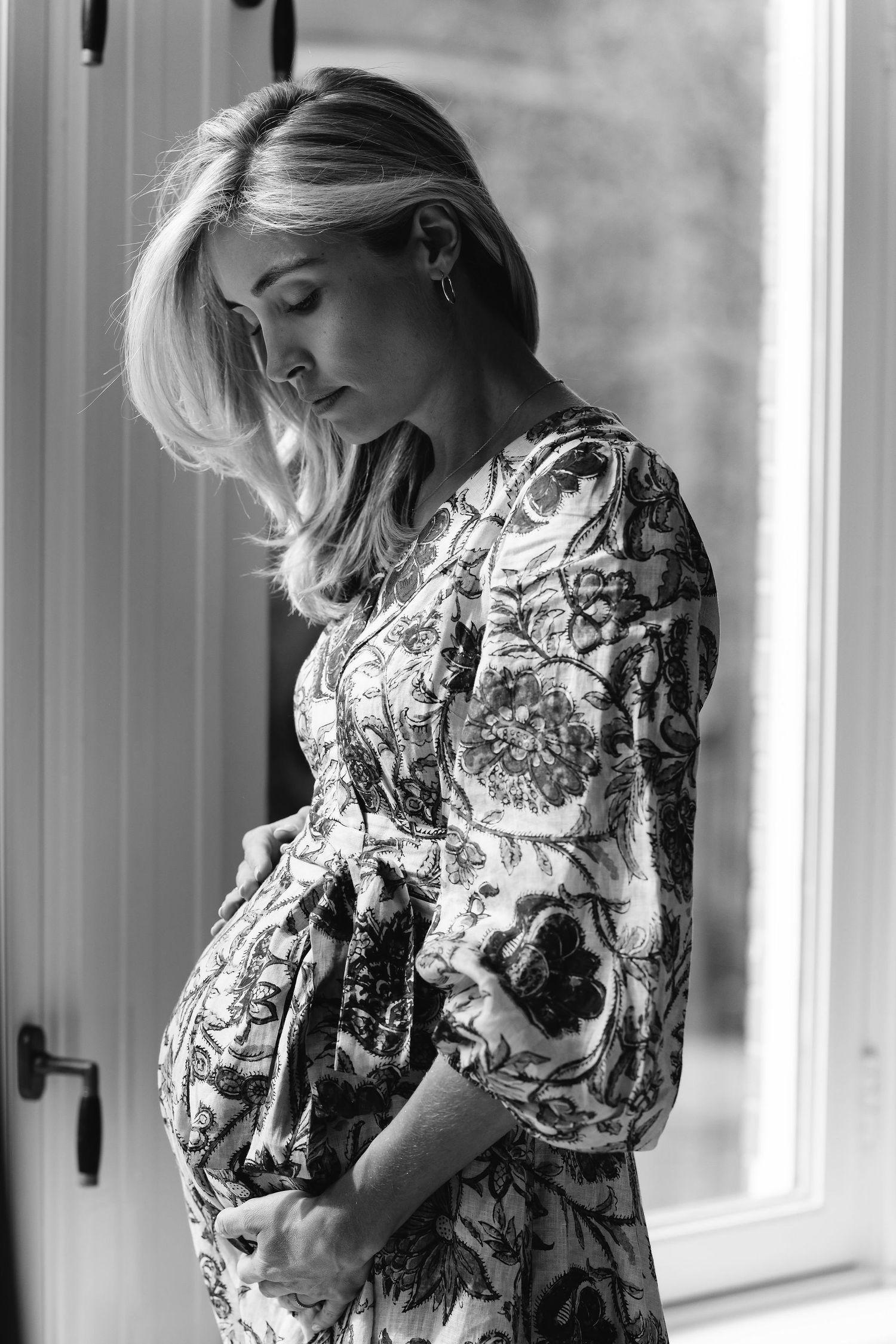 Fashion series showing floral print dress poses by bright windows.