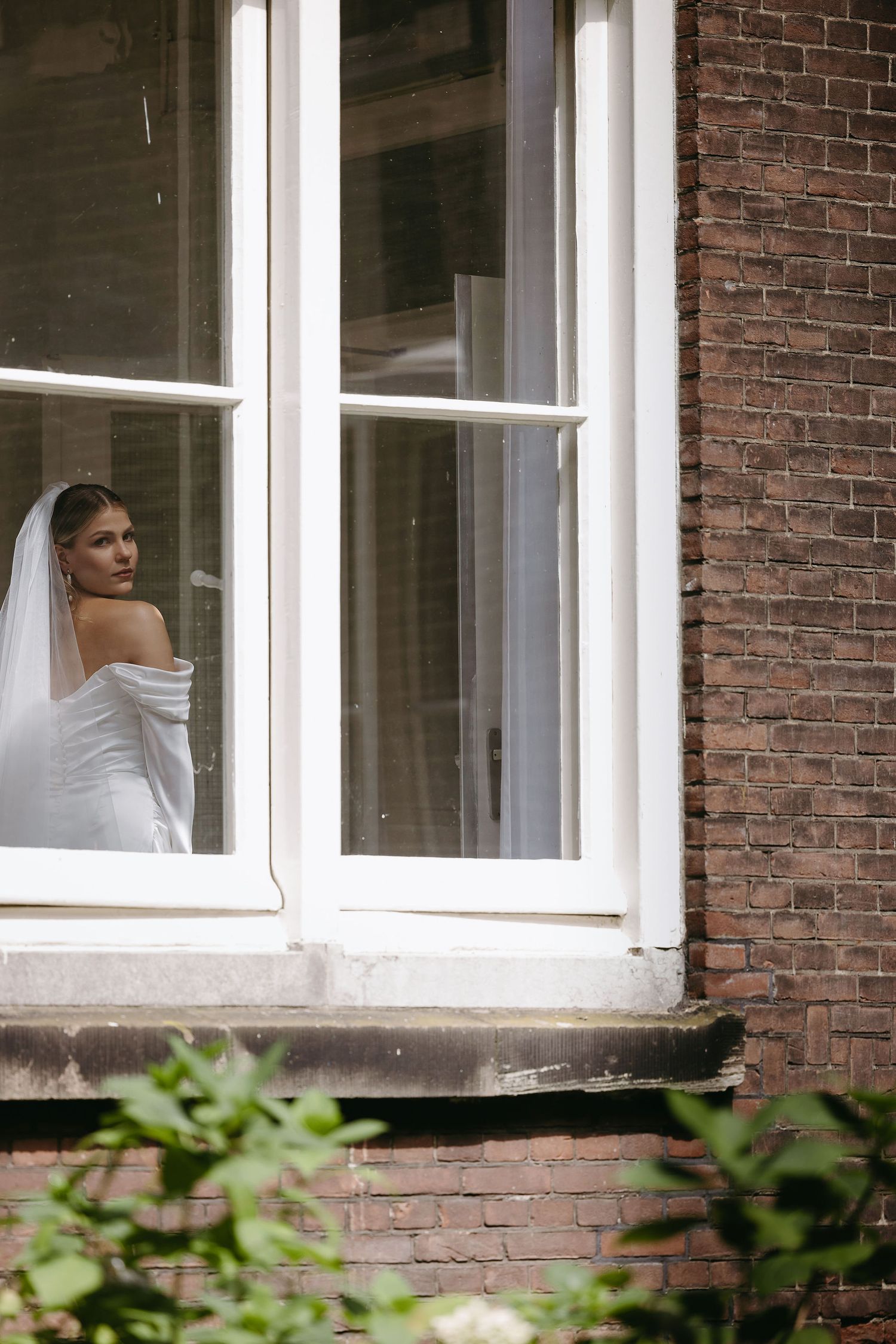 Looking out through white framed windows of a classic brick building interior.