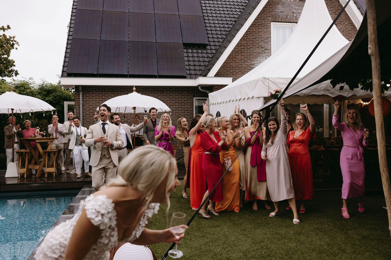 Wedding celebration at poolside venue with colorful decorations and festive atmosphere.