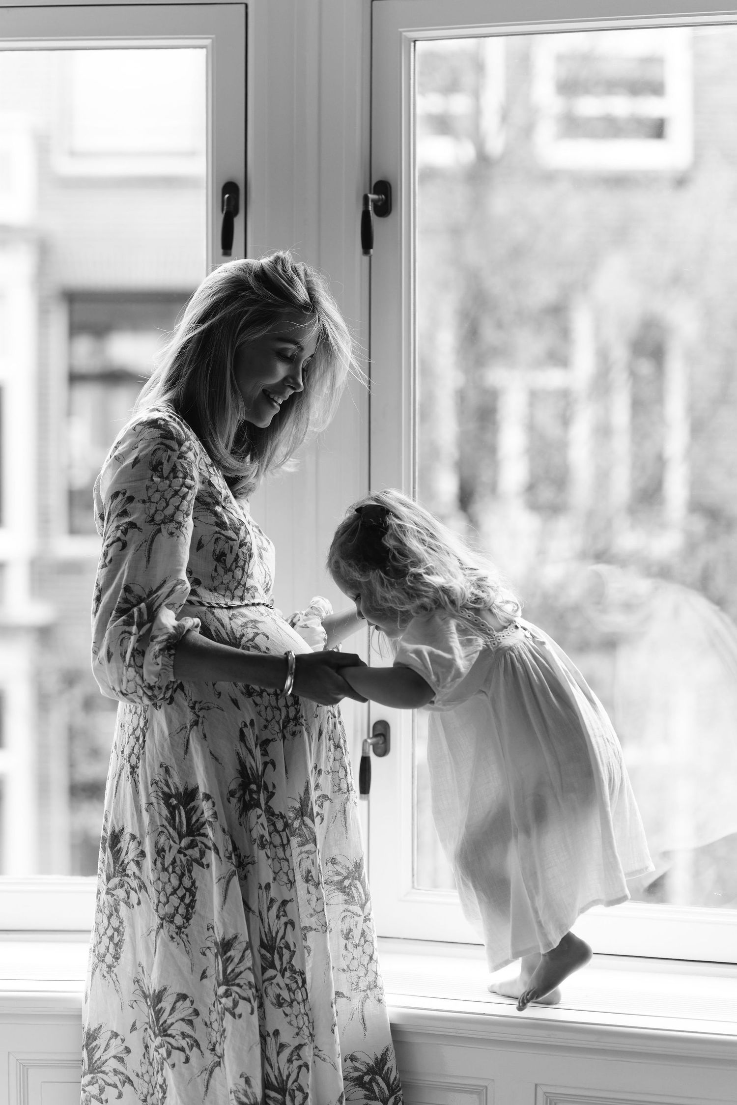 Ethereal sequence of a flowing white floral dress by a bright window creating a dreamy atmosphere.