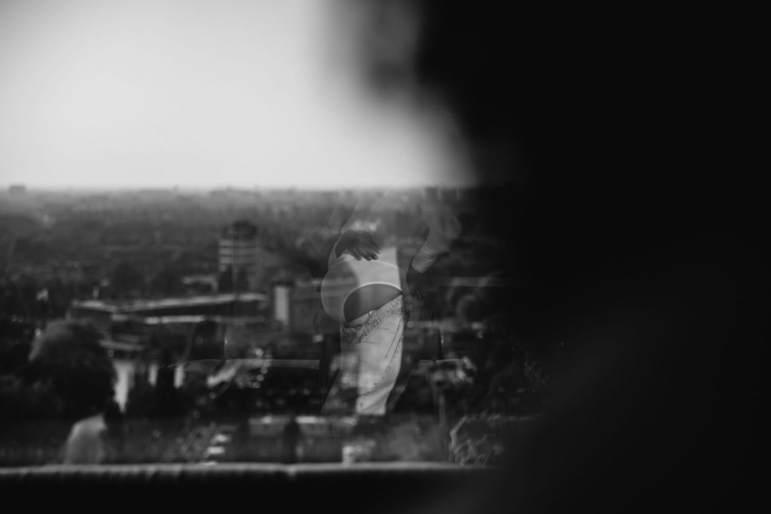 Blurred black and white cityscape view from above showing buildings and urban sprawl.