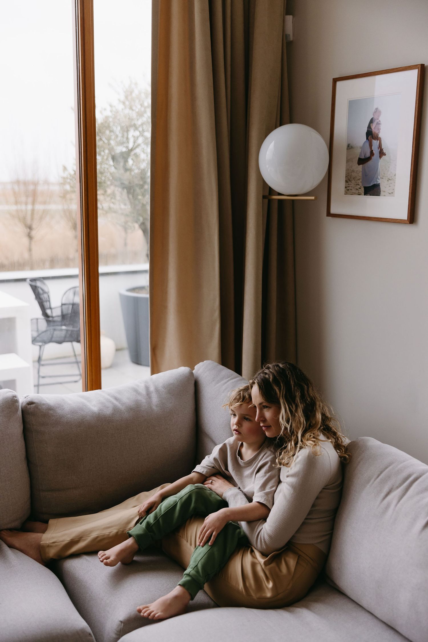 A cozy moment of relaxation on a grey sofa by the window with natural light streaming in.