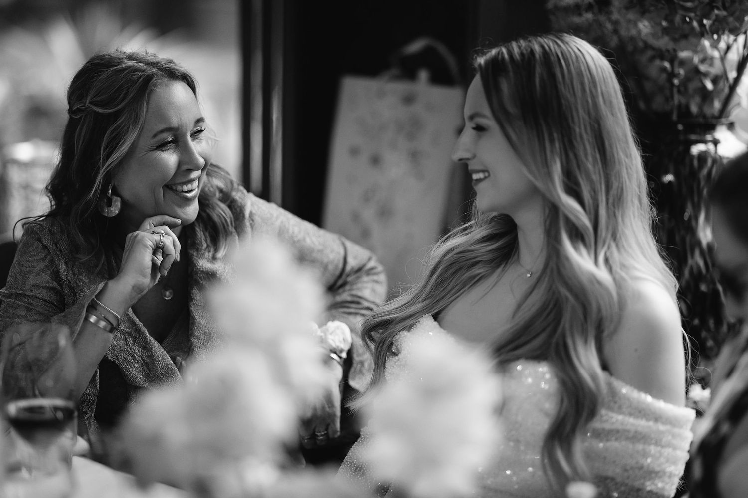 Two wedding guests share a joyful moment during reception.