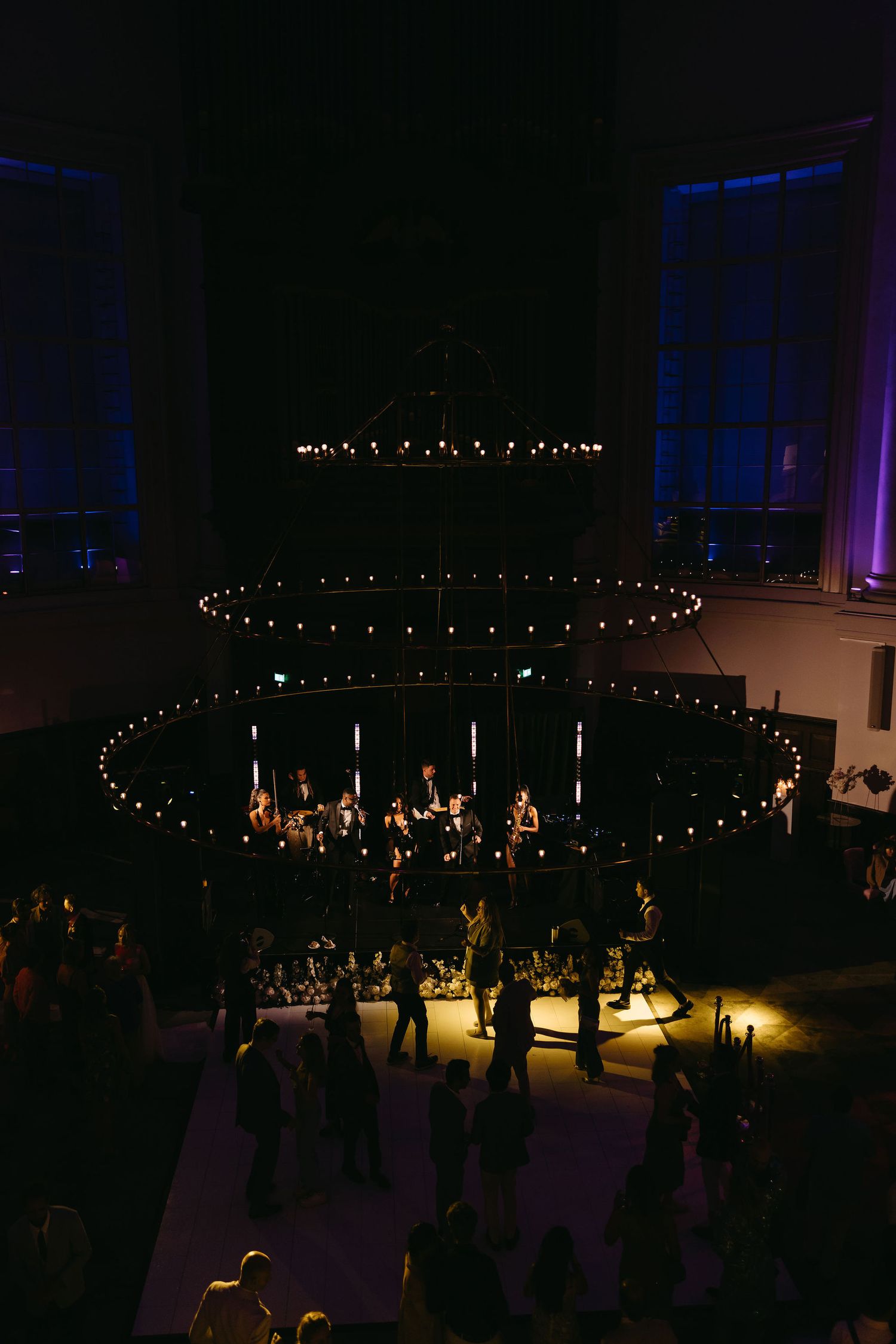 Dramatic overhead lighting installation creates concentric circles above a dark dance floor at an event venue.