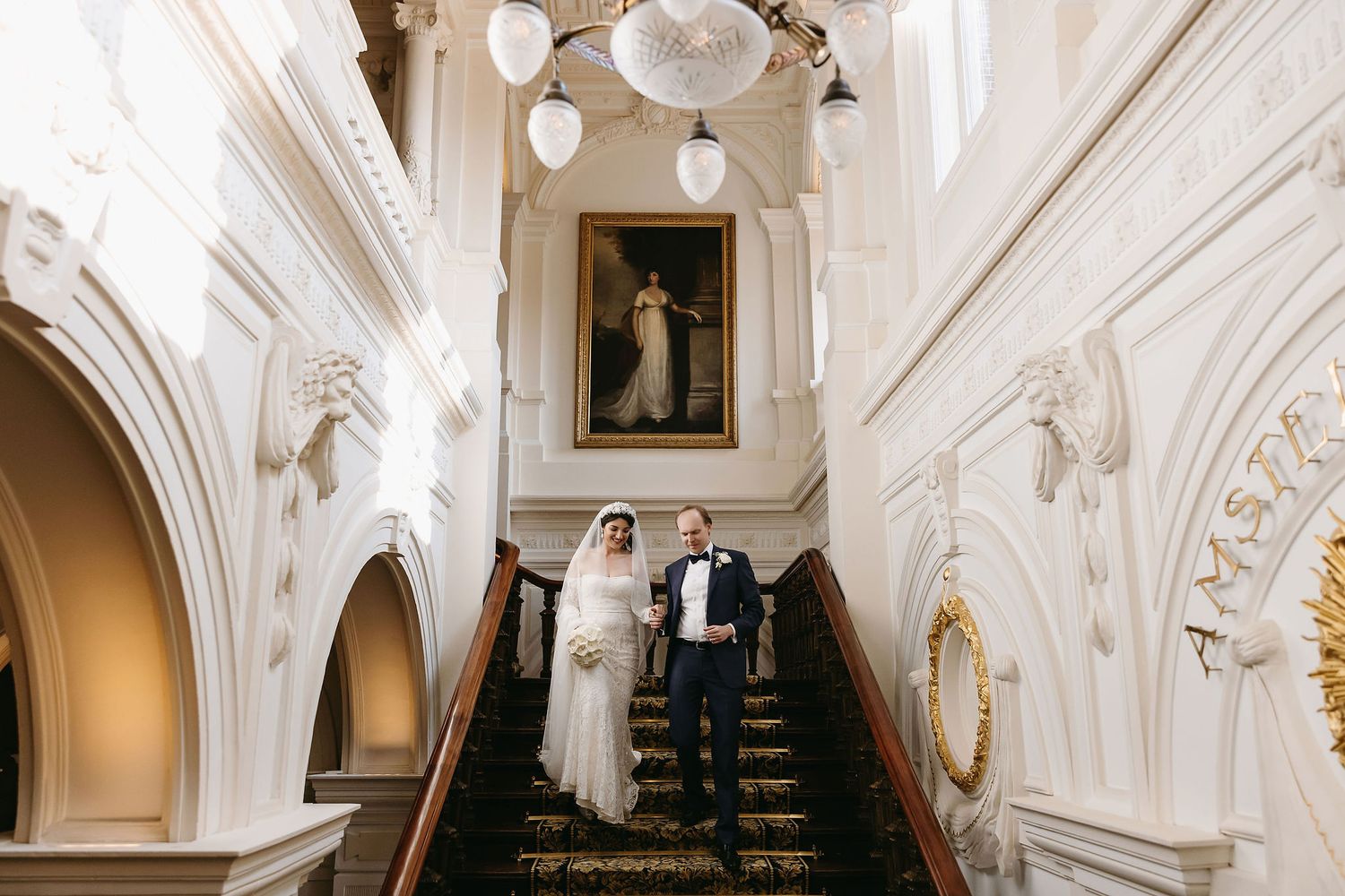 Stunning white marble ballroom with crystal chandeliers and ornate architectural details.