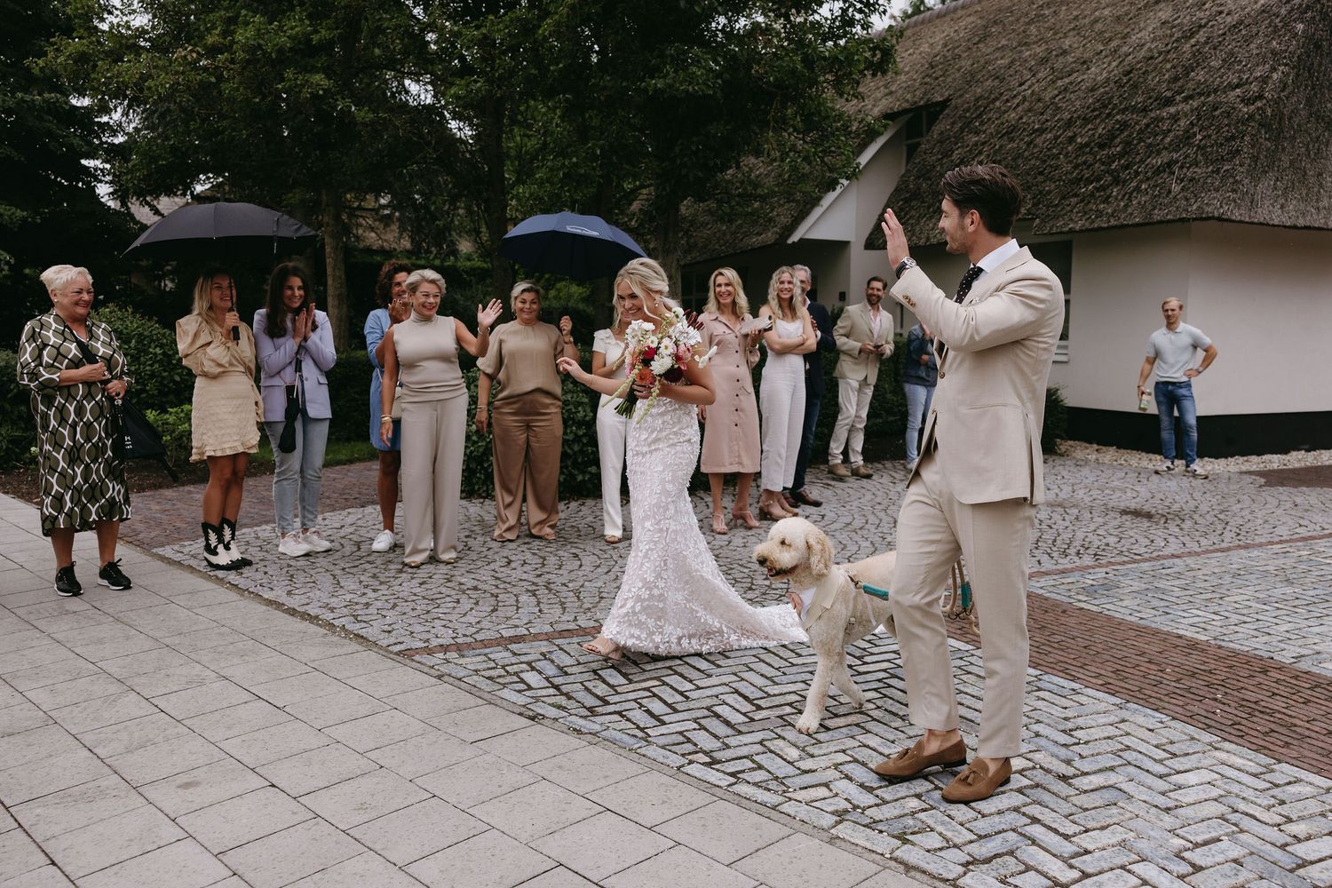 Wedding celebration on cobblestone courtyard with guests watching a couple dance.