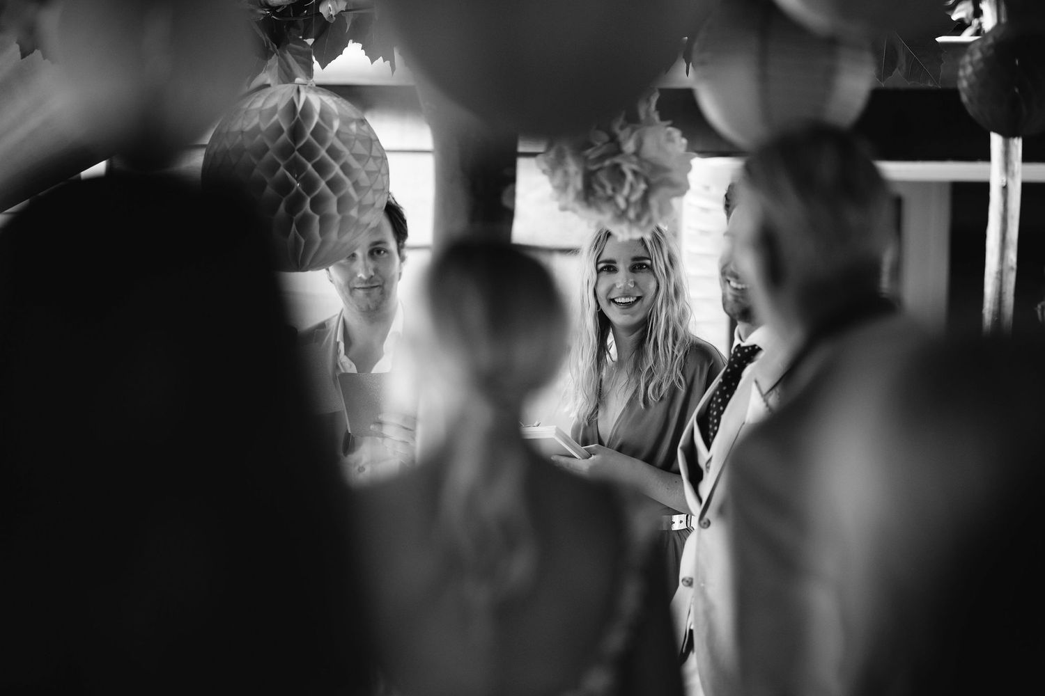 Black and white candid photo of wedding reception festivities.