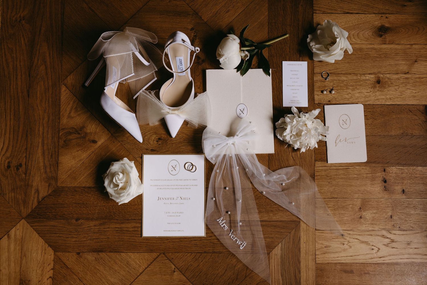 Wedding stationery and decorative elements arranged on rustic wooden surface.
