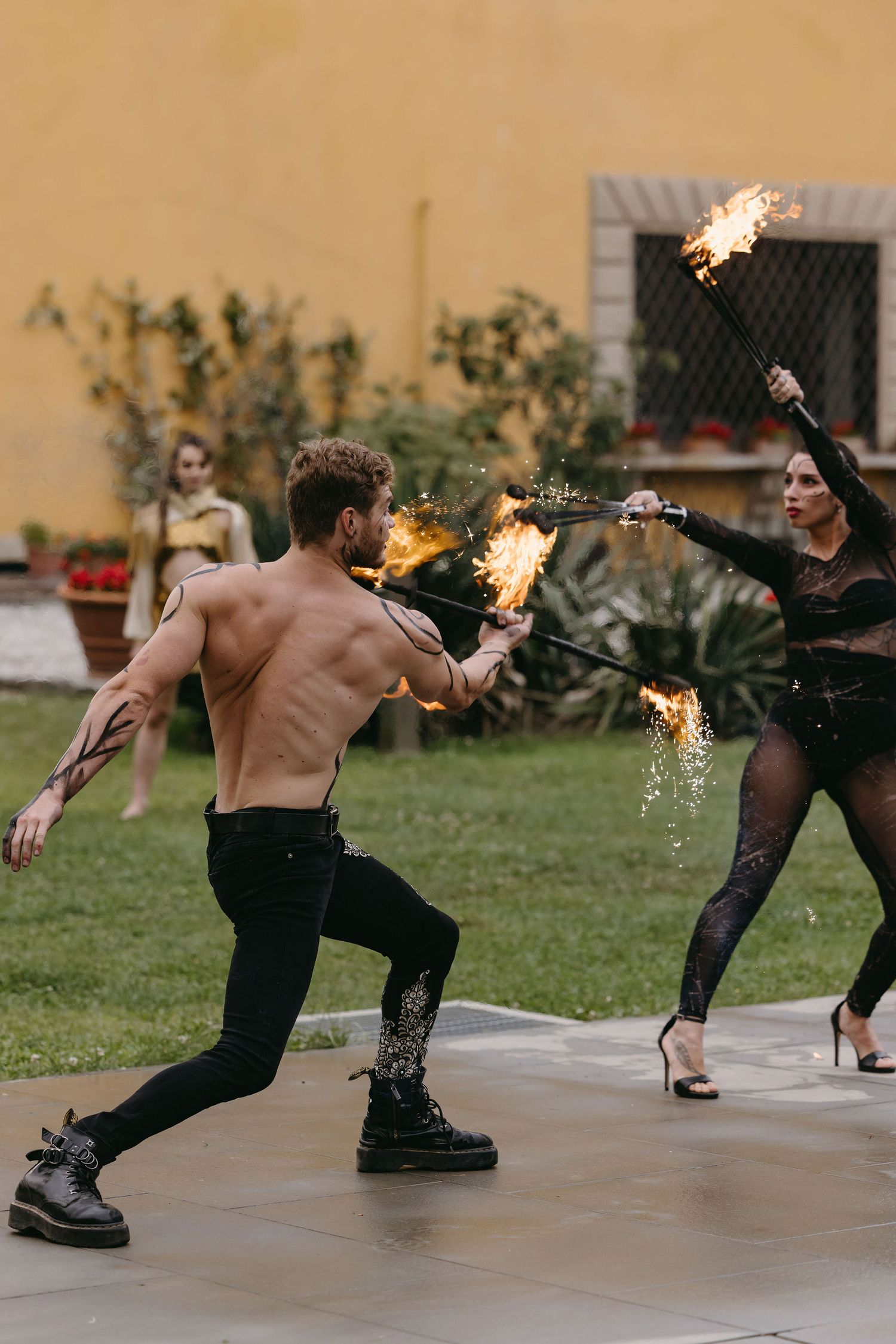 Fire performers putting on a dramatic show at an outdoor wedding entertainment.