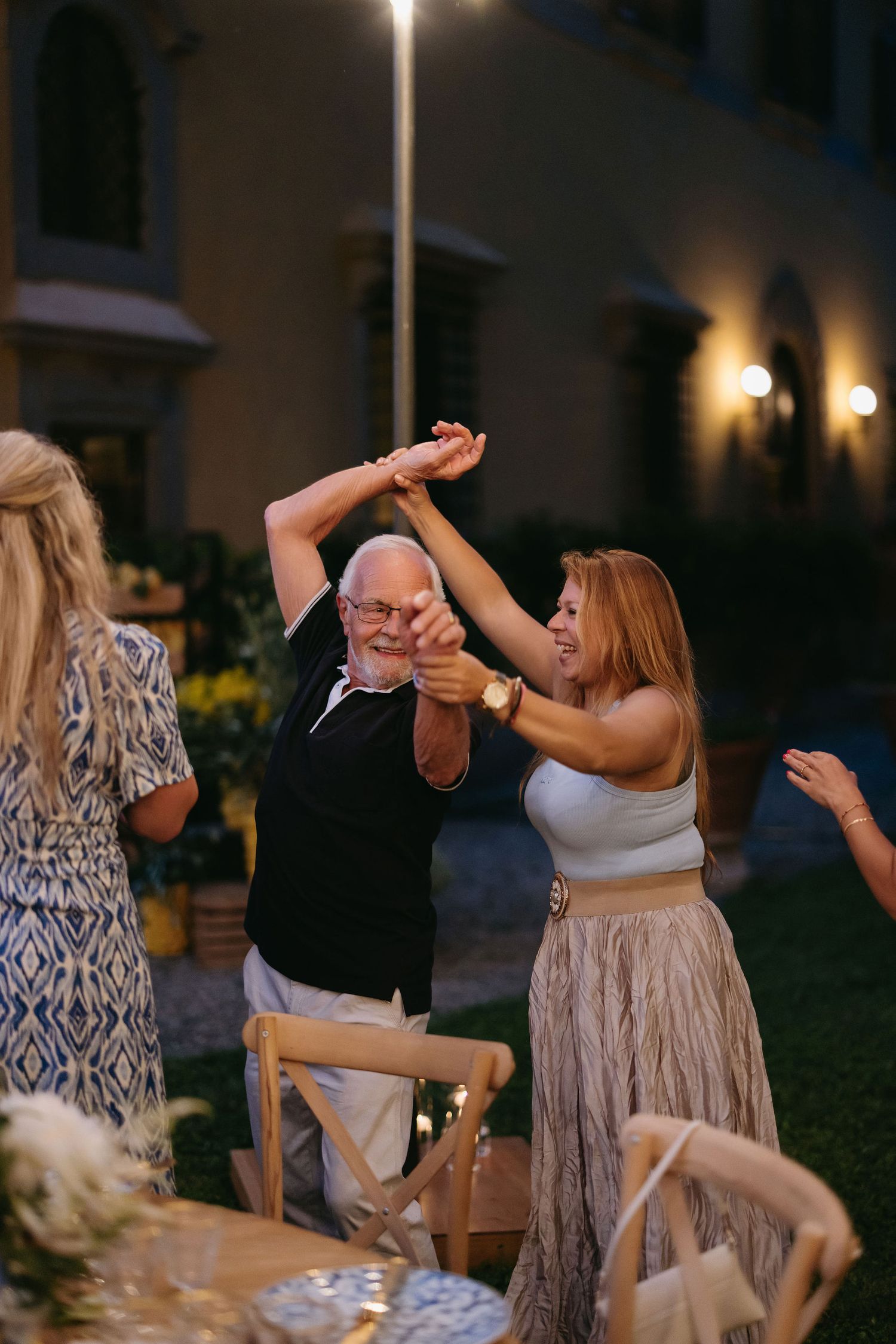 Wedding guests dancing at an outdoor evening celebration.