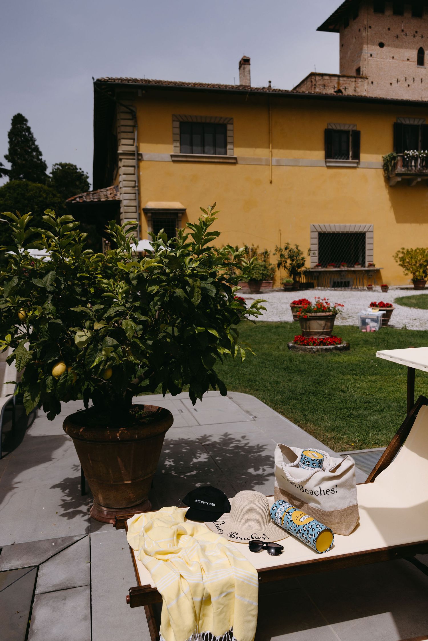 Sunny Italian villa terrace with lemon tree and lounge chair setup.