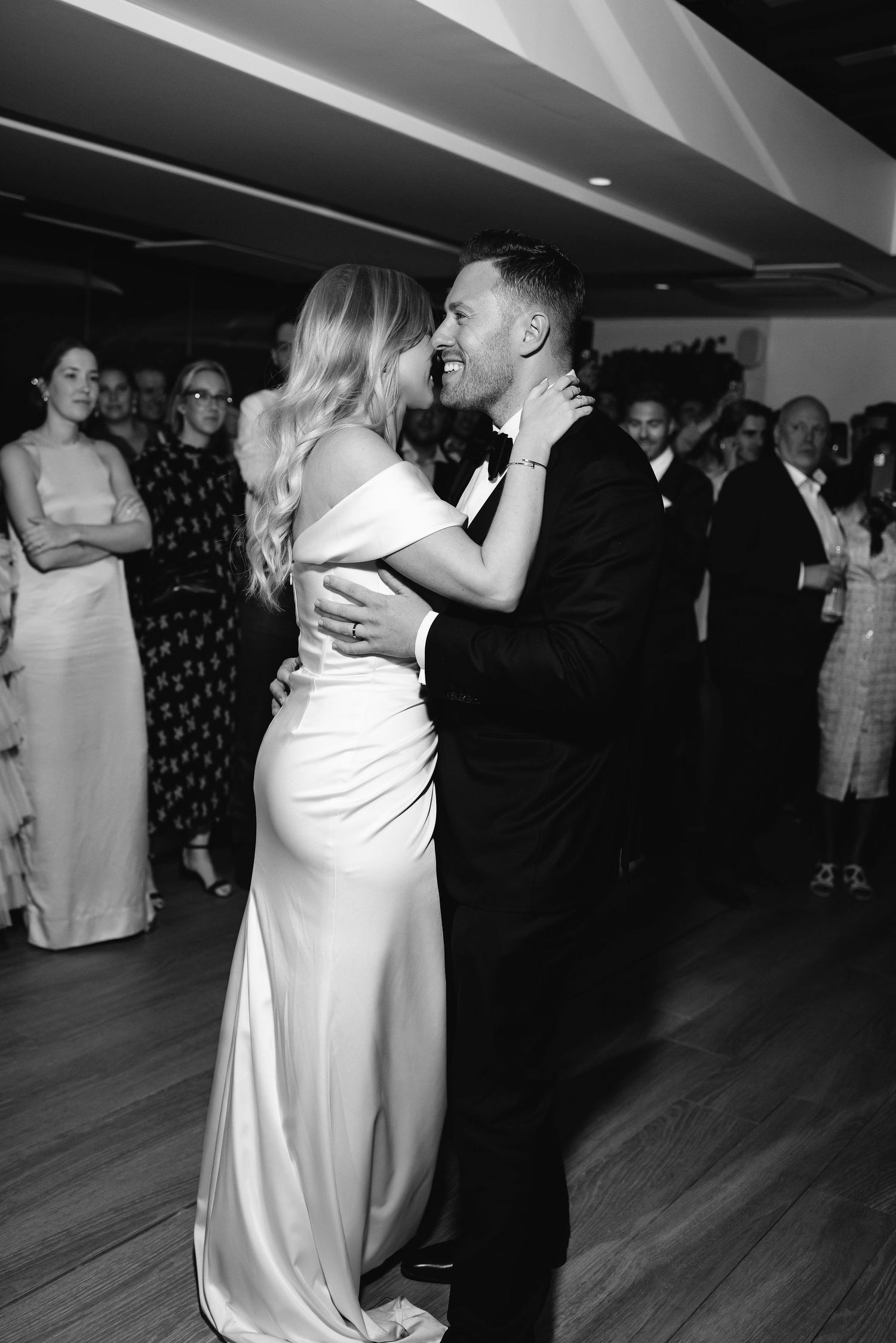 Couple sharing their first dance at wedding reception in black and white.