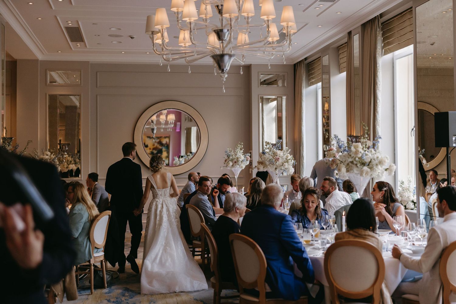 Luxurious wedding reception hall with crystal chandeliers and classic architectural details.