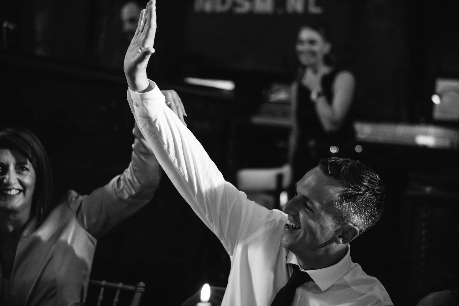 Black and white portraits show joyful moments of dancing and celebration at a wedding reception.