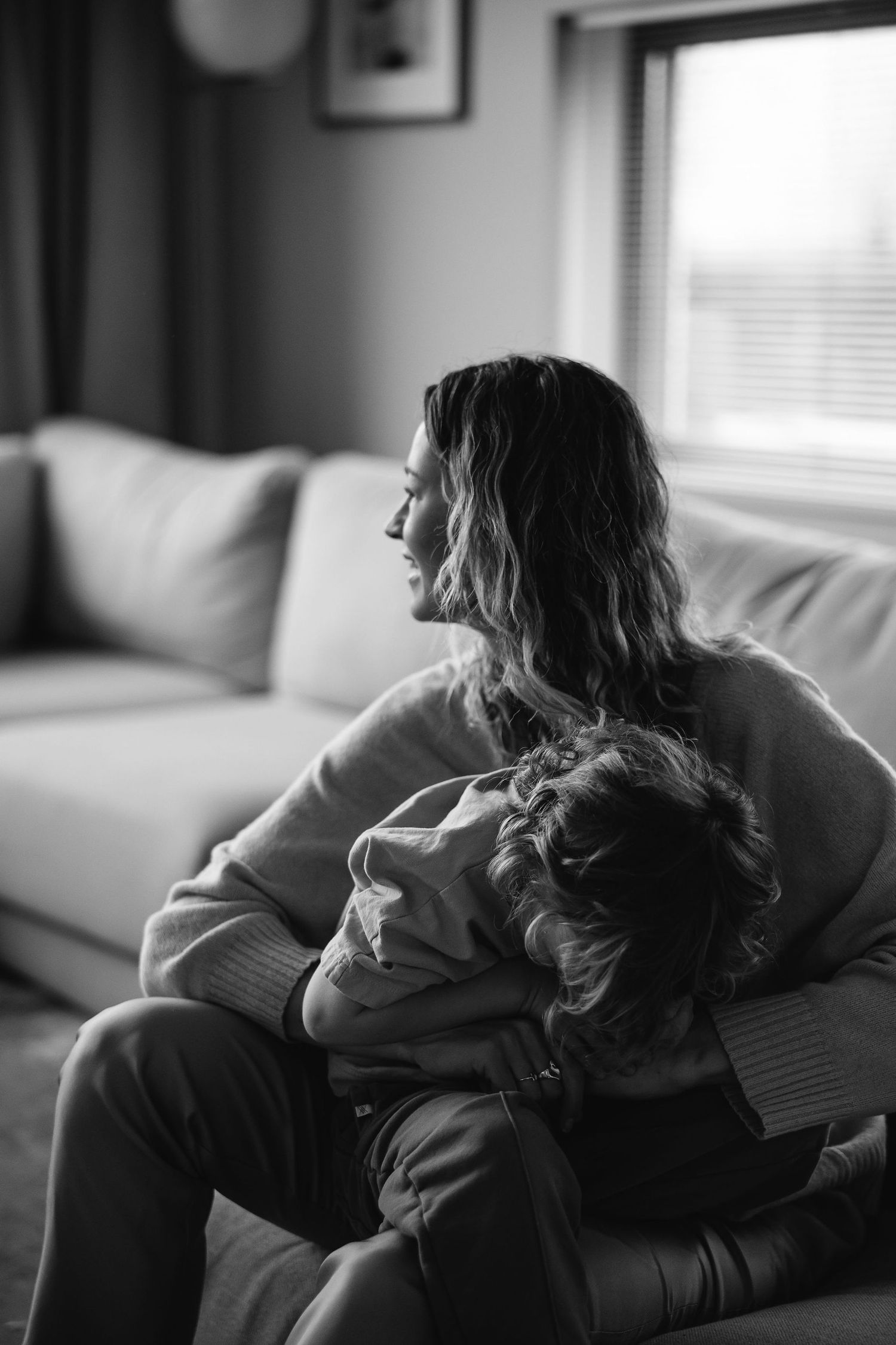 Black and white photos capture quiet moments of rest and connection on a couch.