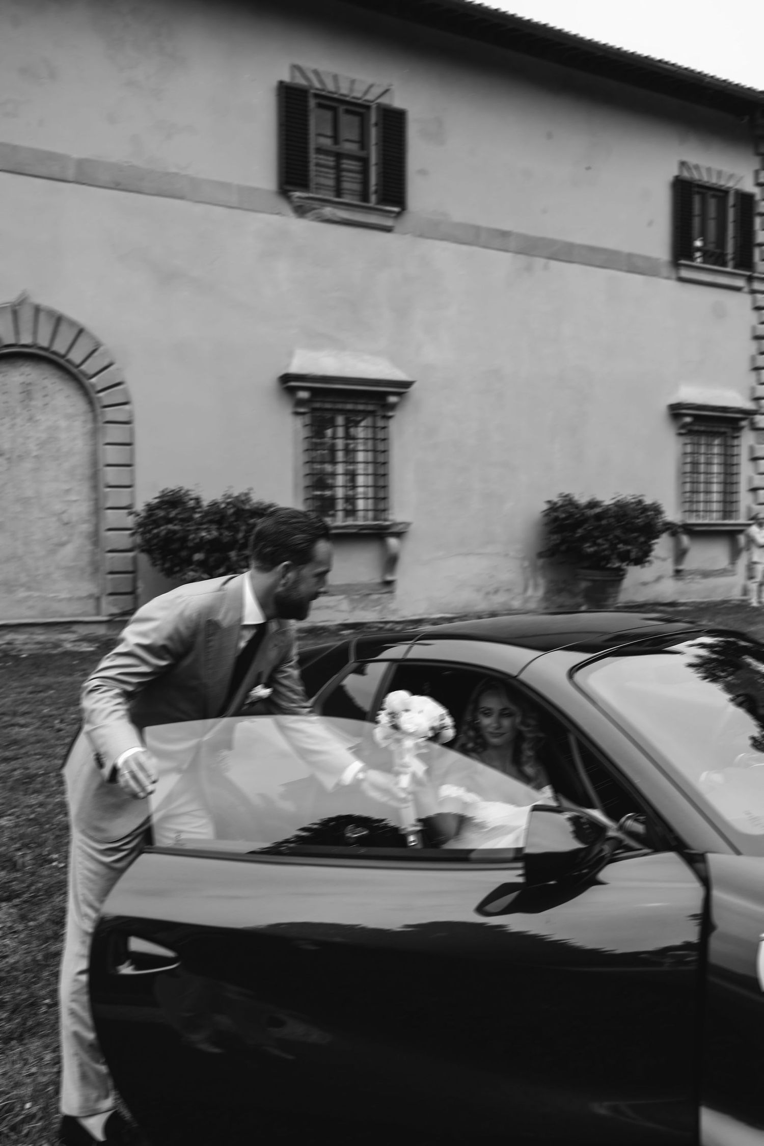 A series of black and white photographs showing two people interacting through a car window on a street.