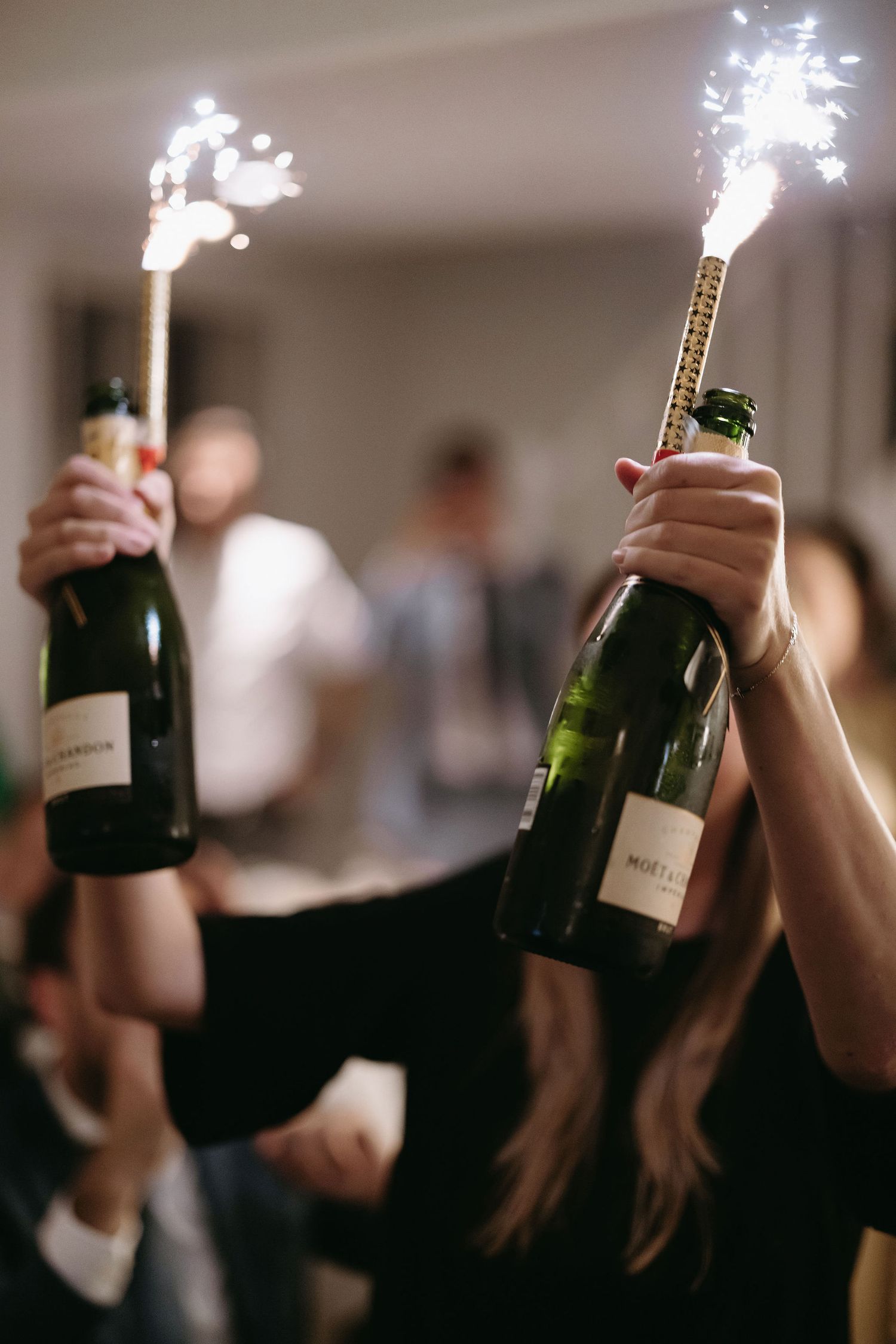 Wedding celebration with champagne bottles topped with sparklers creating a festive atmosphere.