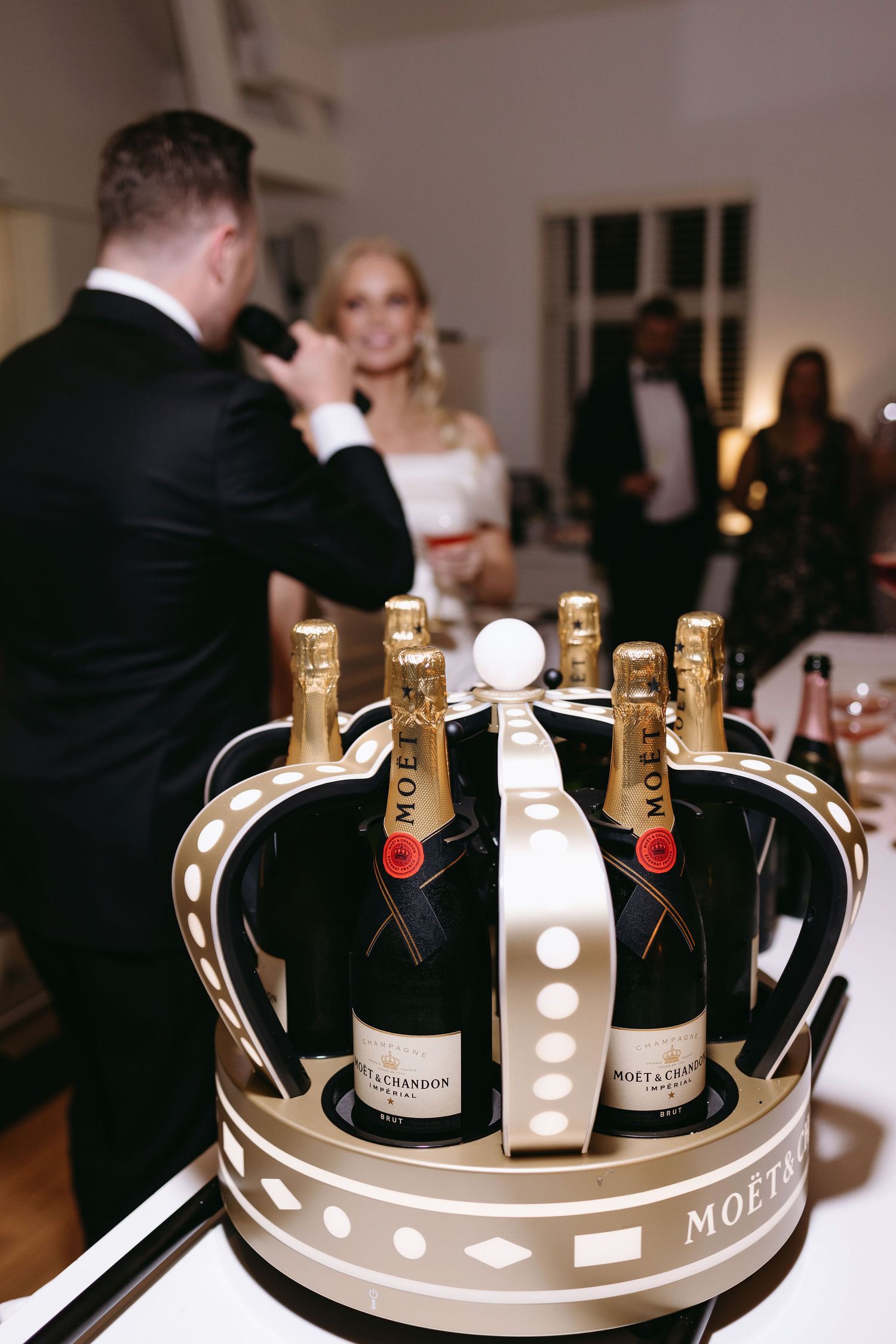 Luxury Moët champagne display in decorative crown-shaped holder at wedding reception.