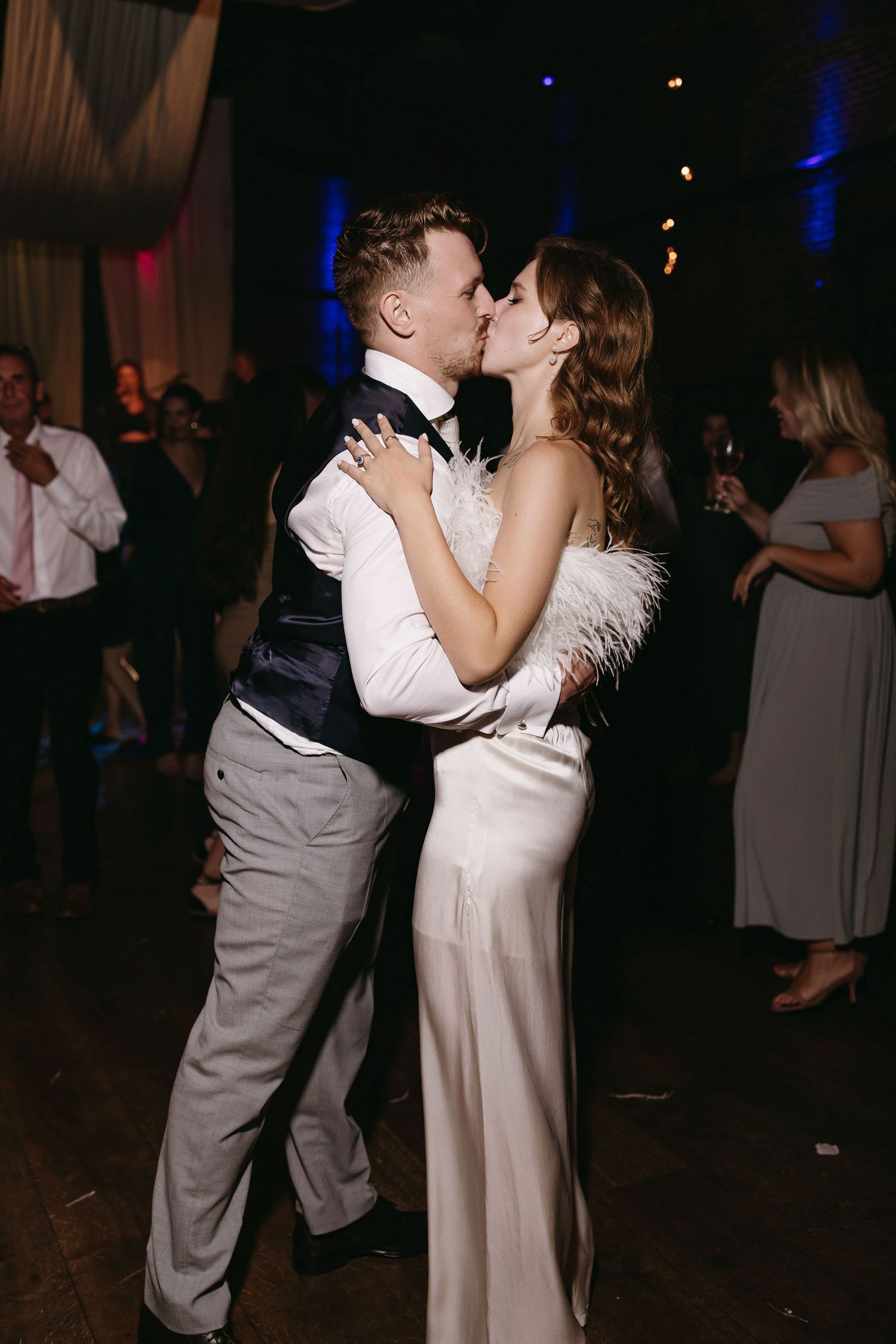 Romantic slow dance moments captured during wedding reception in dimly lit venue.