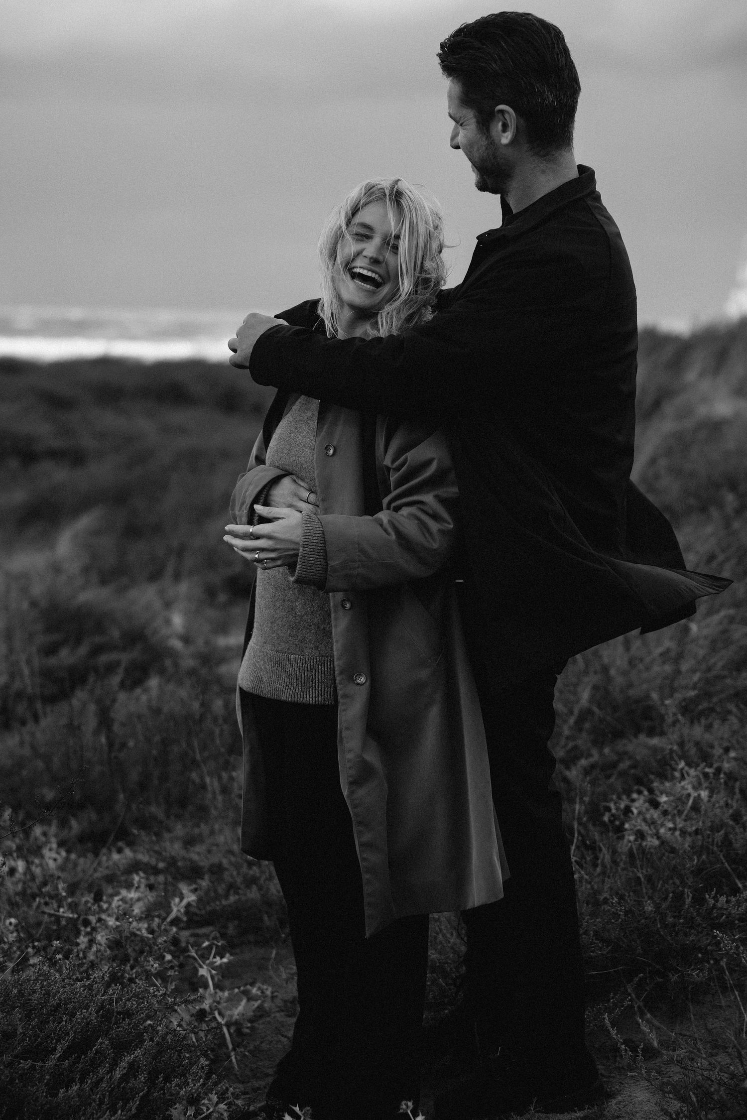 Romantic black and white outdoor portraits of couple embracing in natural setting.