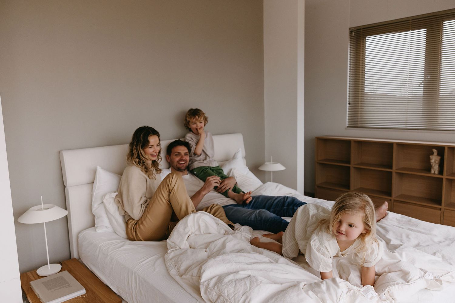 Series of intimate lifestyle photographs on a white bed in natural window light.