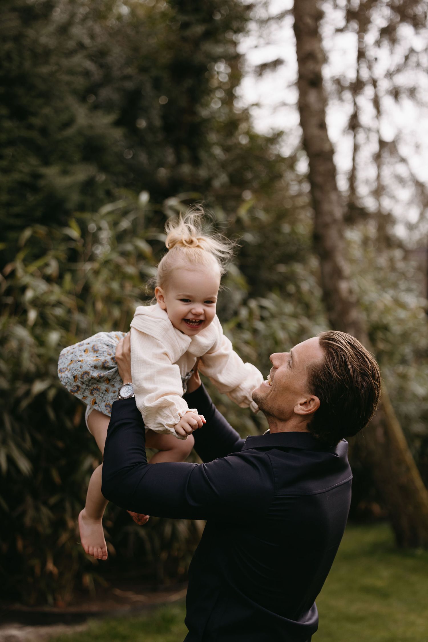 Joyful outdoor moments captured between two people against forest backdrop.