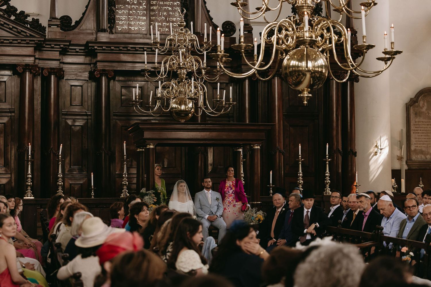 Interior of a grand historic building with ornate chandeliers and architecture.