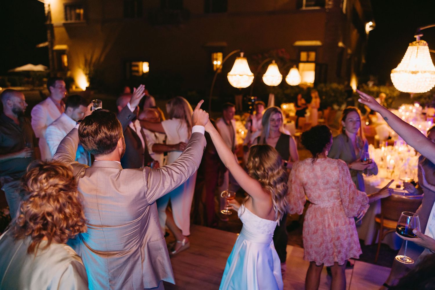 Evening dance party with purple lighting and people dancing in celebration.