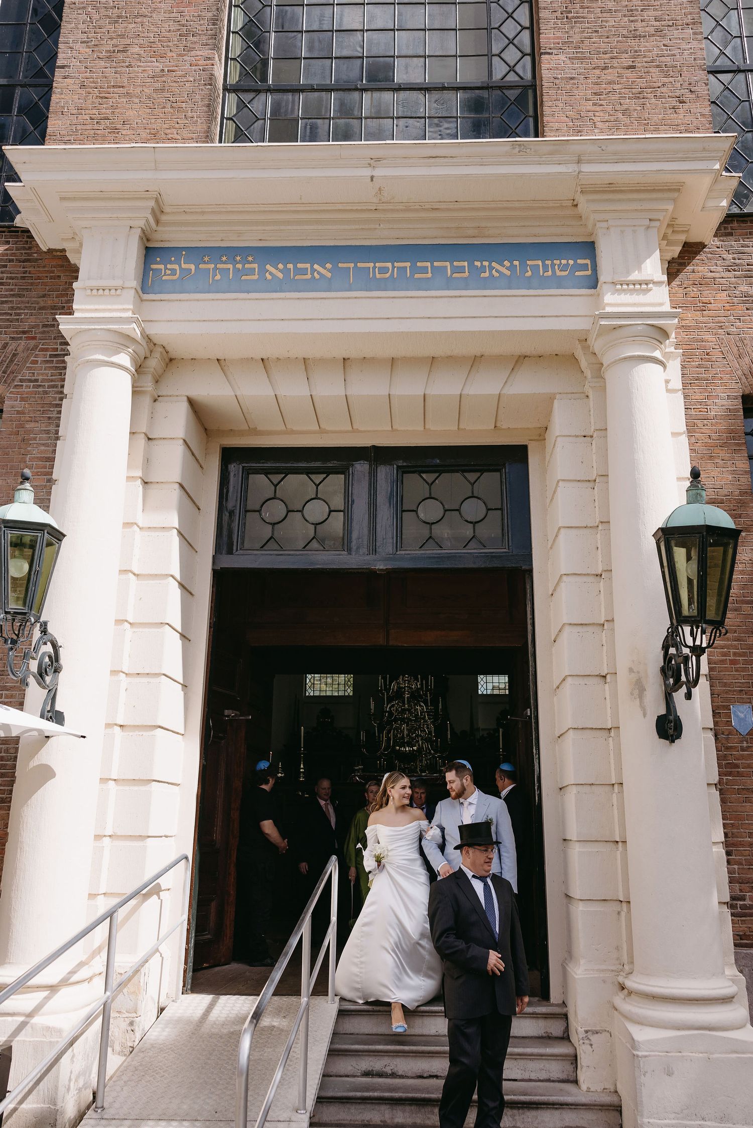 A classical brick building entrance with white columns and ornate doorway details.