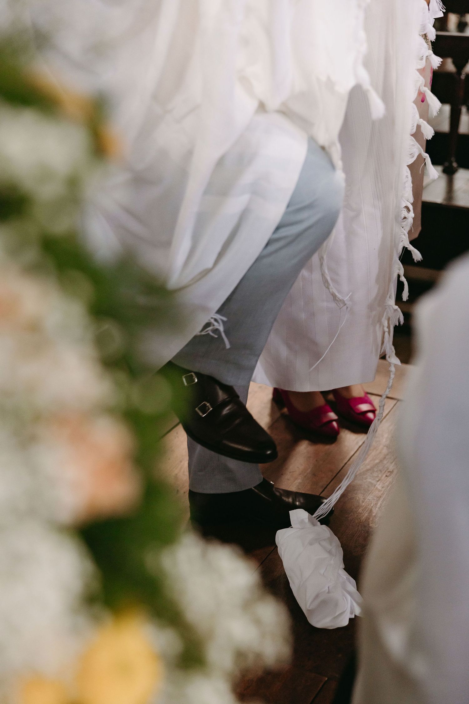 Close-up detail shot of formal shoes and wedding dress hem.