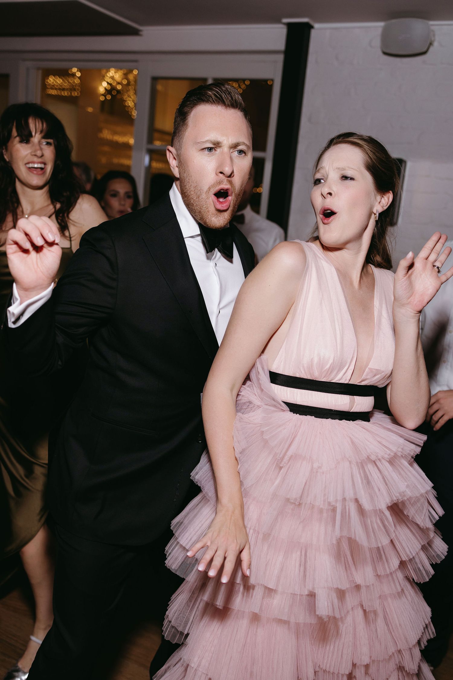 Wedding guests dancing and celebrating at reception party.
