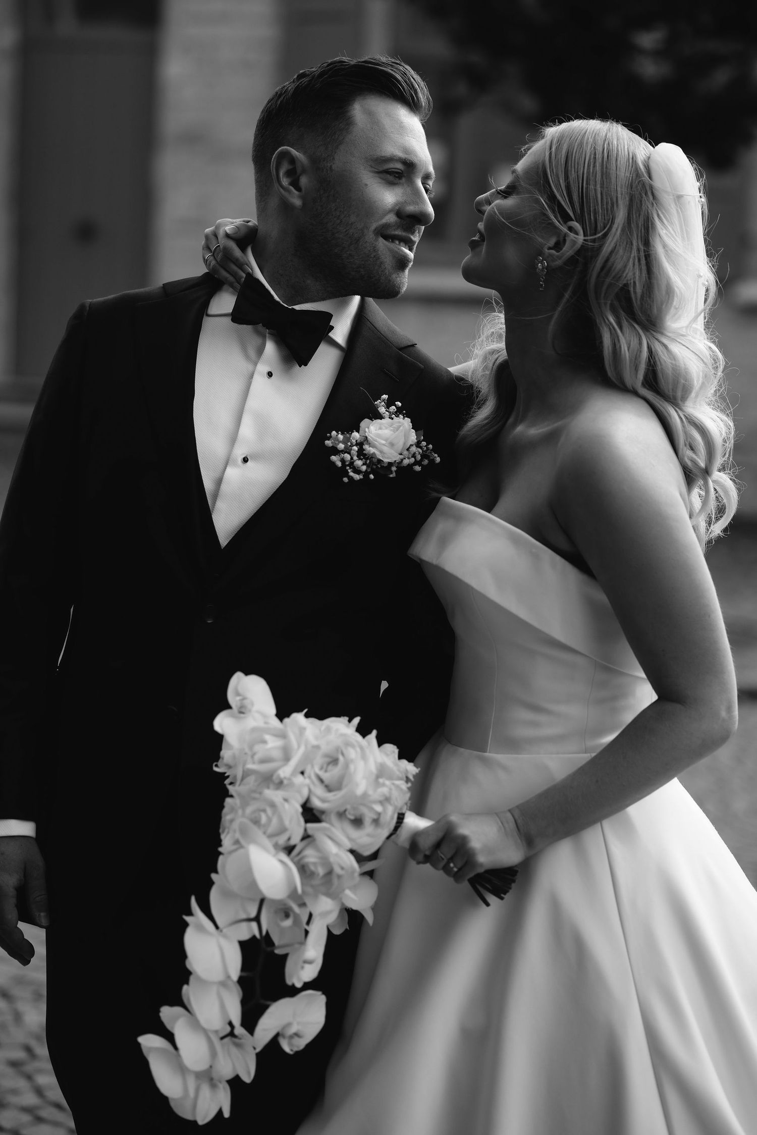 Black and white portrait showcasing elegant wedding day attire and a beautiful bouquet.