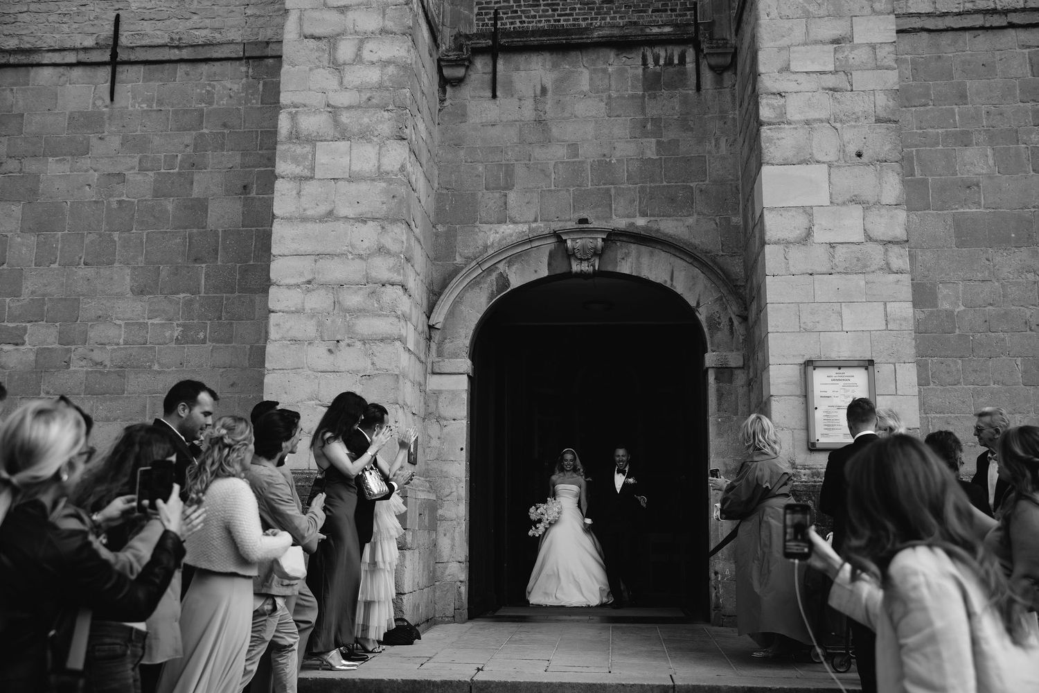 Couples dancing together in a rustic stone-walled venue during a wedding celebration.