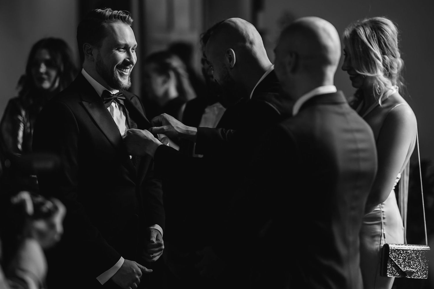 Black and white candid photograph of wedding reception conversation.