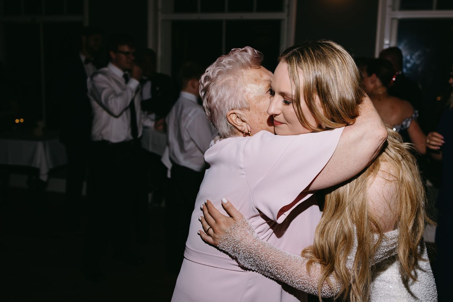 Emotional embrace between two people at wedding reception.