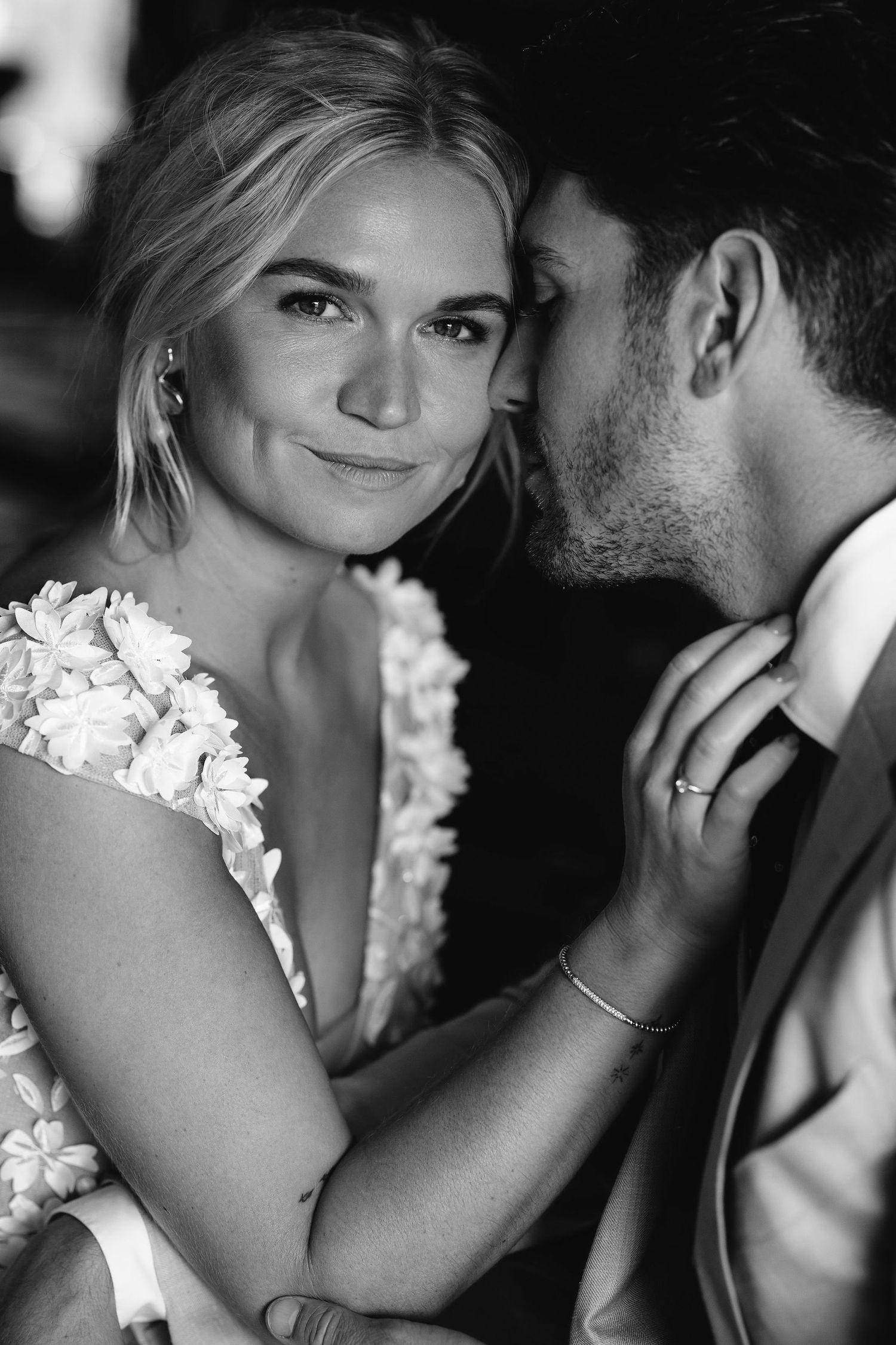 A romantic black and white close-up portrait showing tender intimacy between a couple.