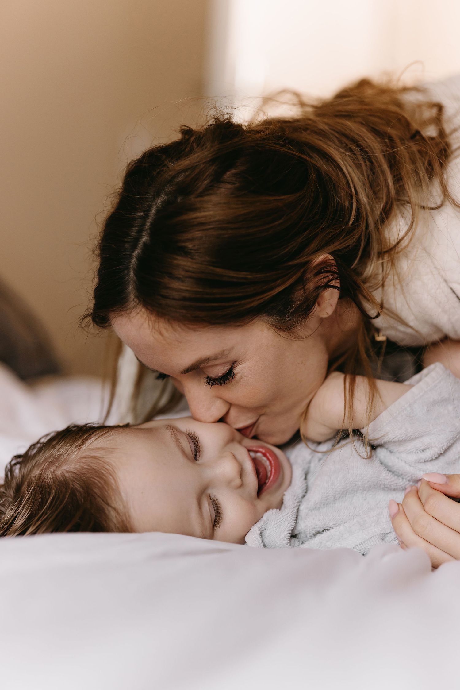 A sweet candid moment of affection and laughter captured in soft morning light.