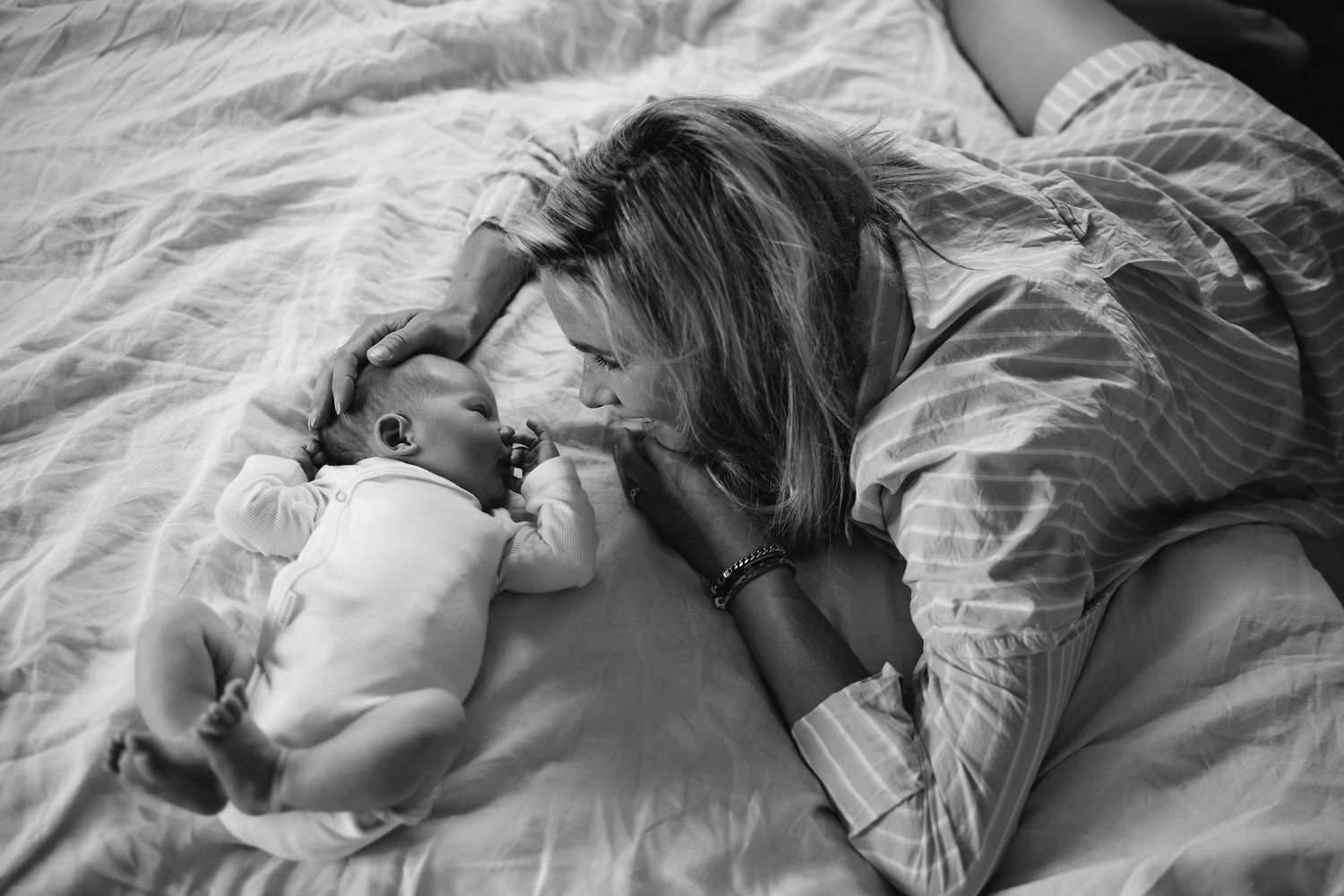 Black and white sequence of intimate moments captured on soft white bedding.