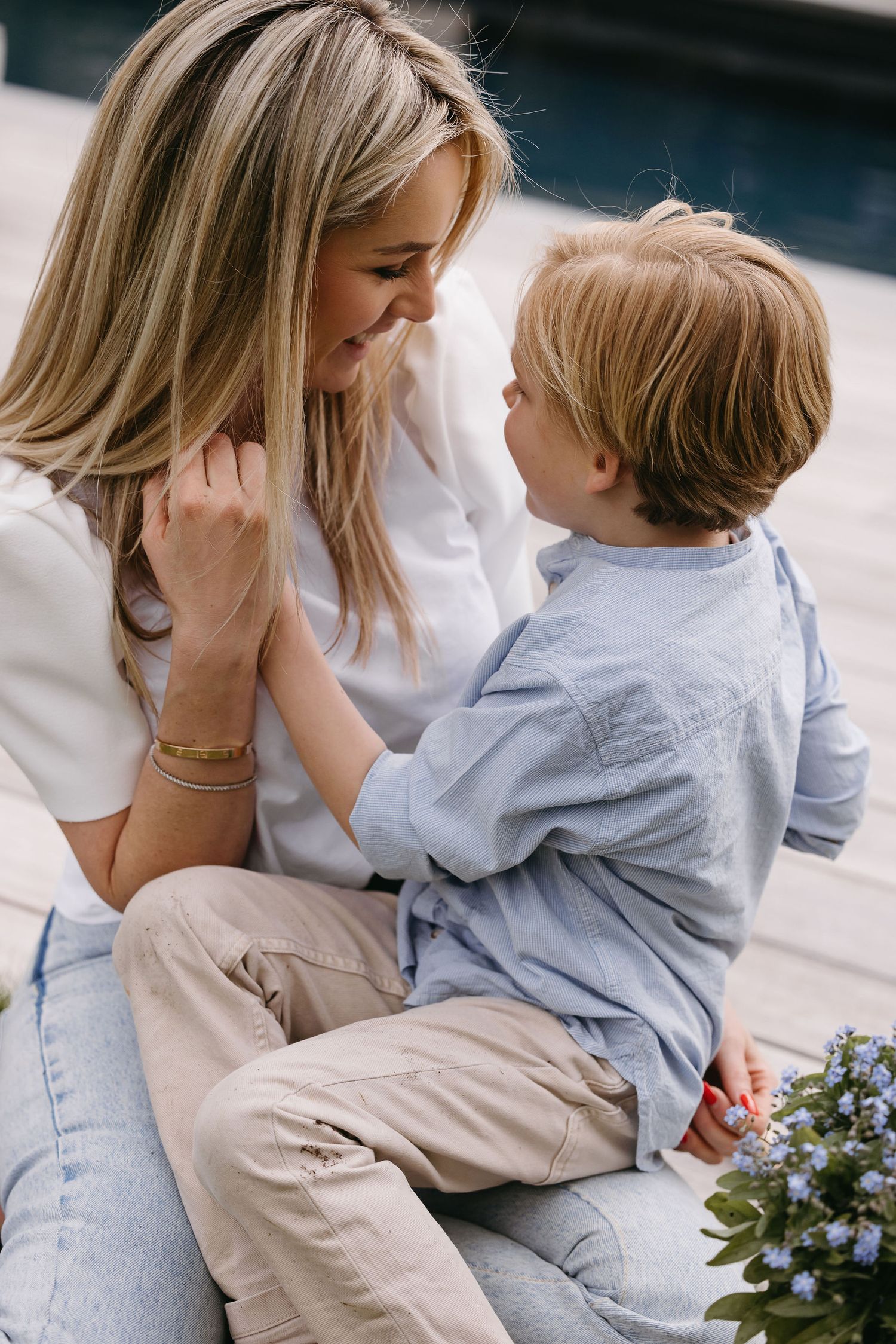 Tender moment captured between parent and child in casual denim and white attire.