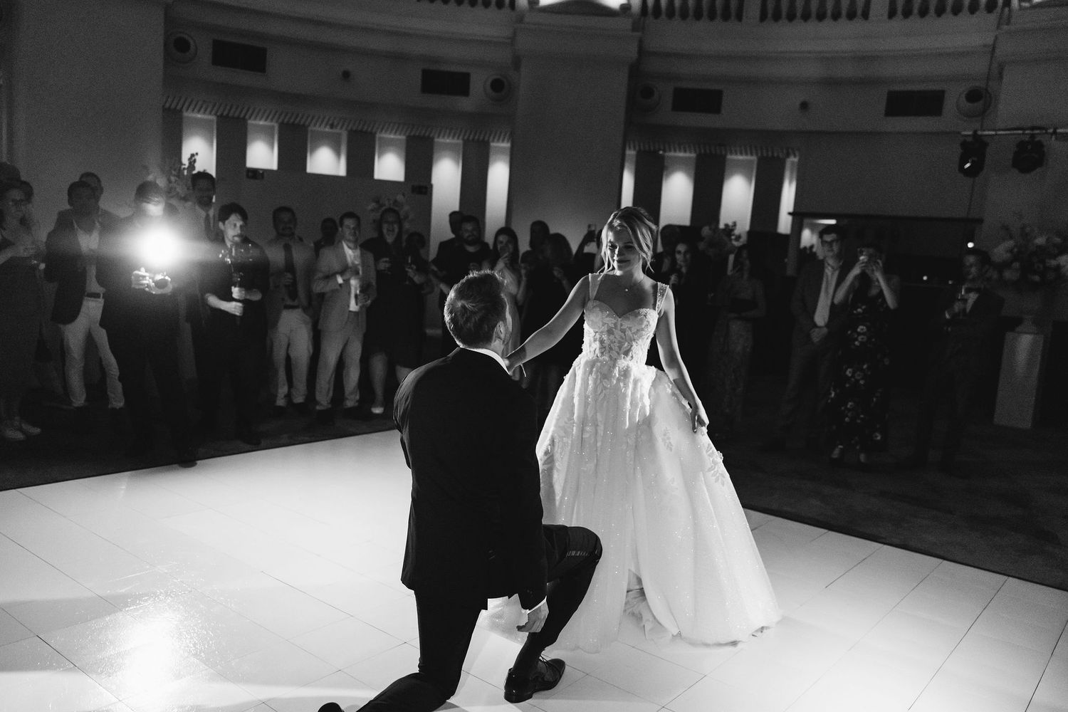 First dance moments captured in black and white on elegant ballroom dance floor.